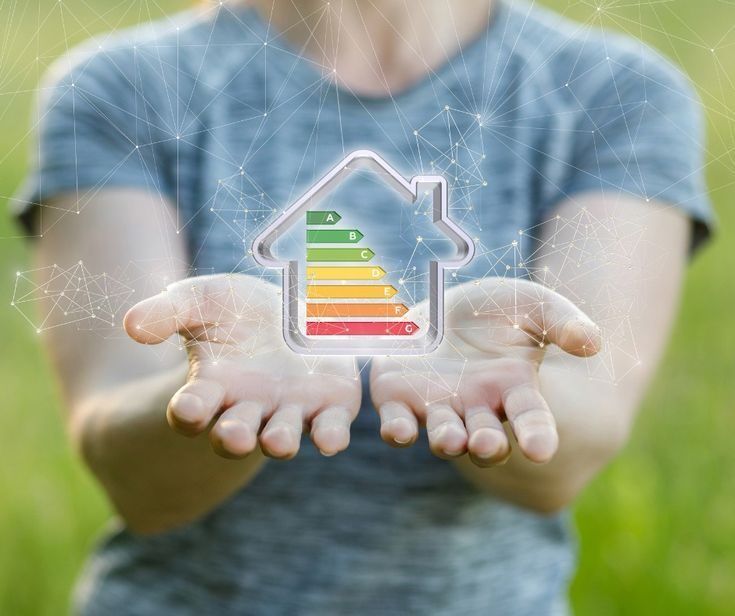 Manos sosteniendo el símbolo de una casa con etiqueta de eficiencia energética